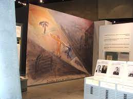 نمایشگاه موزه، نقاشی بزرگی از یک اردوگاه کار اجباری را به نمایش می گذارد.